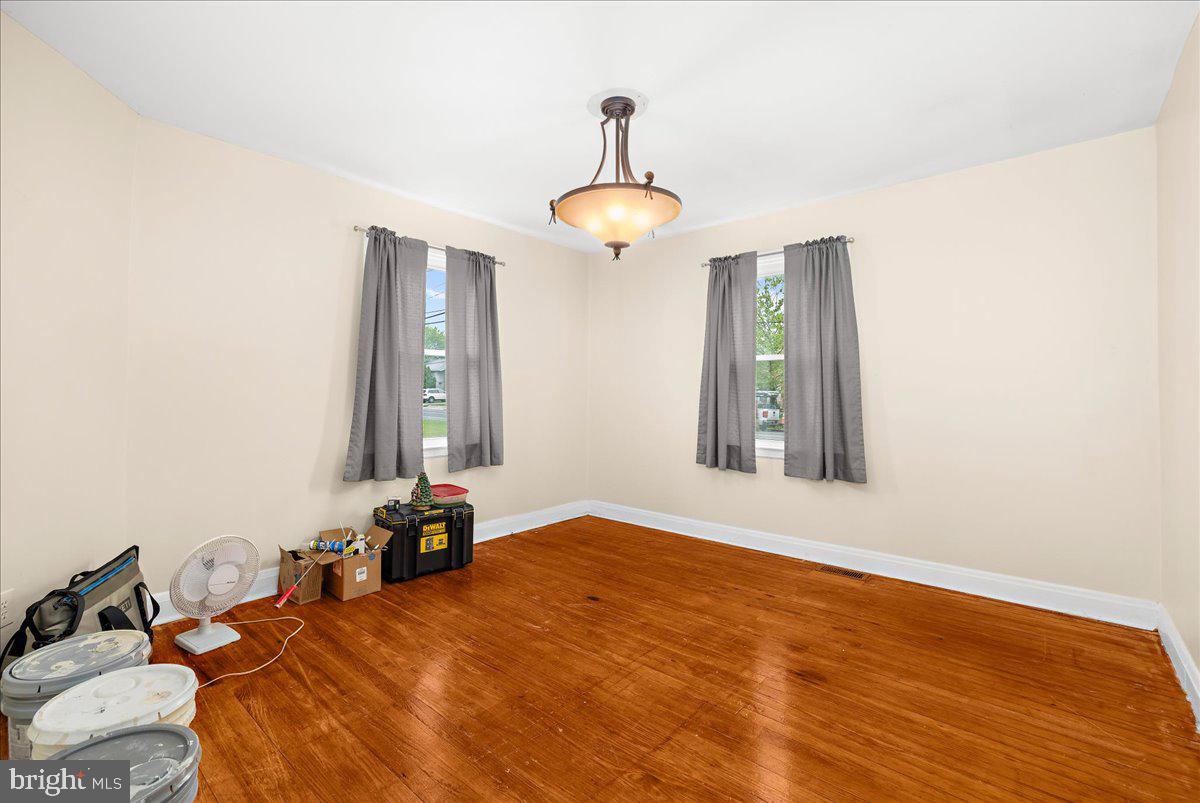 7965 Tick Neck Road Pasadena, MD 21122 - Photo 12 of 63 a bedroom with a bed and a chandelier