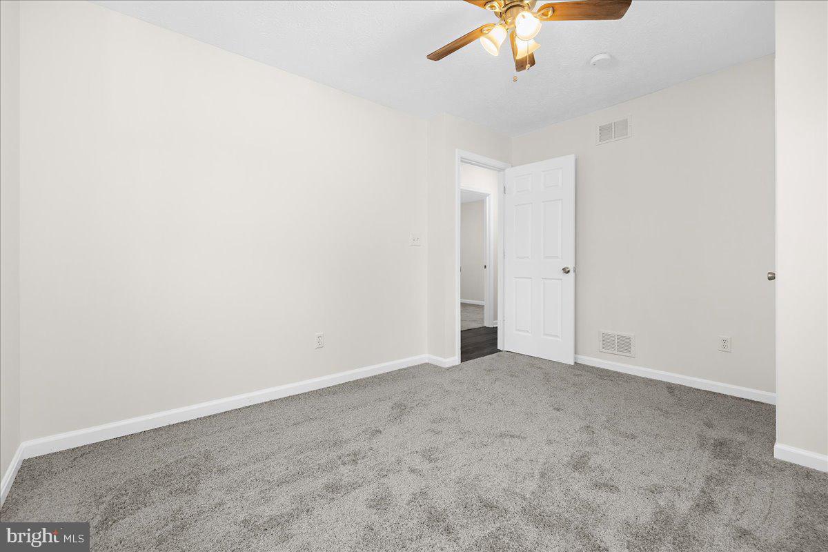 7965 Tick Neck Road Pasadena, MD 21122 - Photo 48 of 63 an empty room with a ceiling fan and carpet