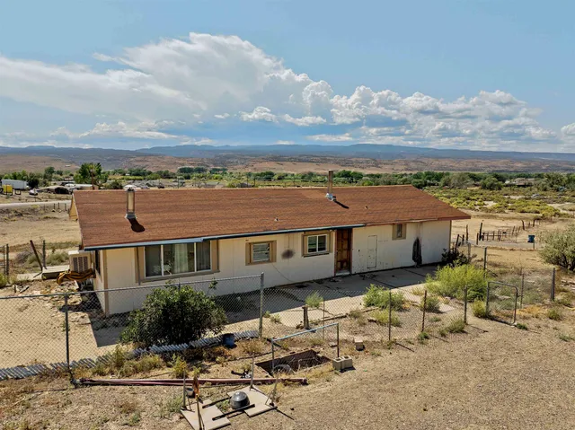 an aerial view of a house with a yard and wooden fence