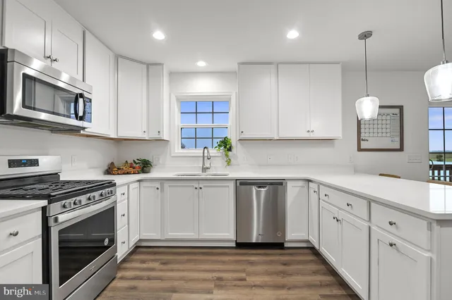 a kitchen with white cabinets stainless steel appliances and sink