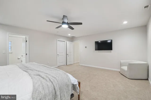 a spacious bedroom with a bed and a flat screen tv