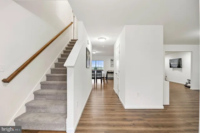 a view of a hallway with wooden floor and staircase