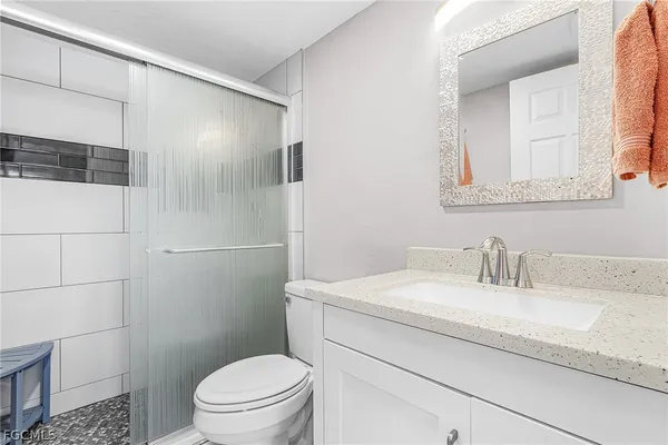 a bathroom with a sink a toilet and shower