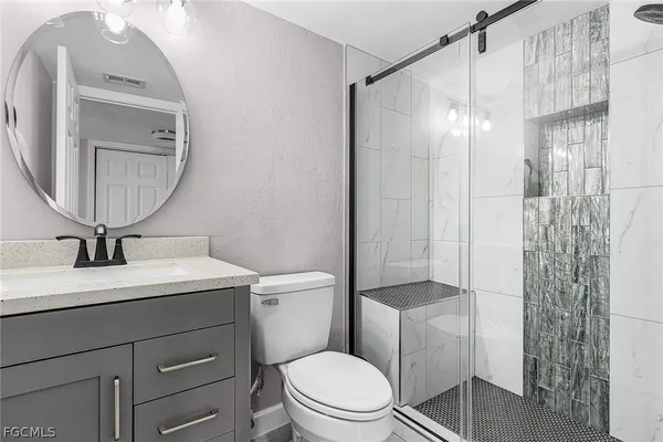 a bathroom with a toilet a sink and a mirror