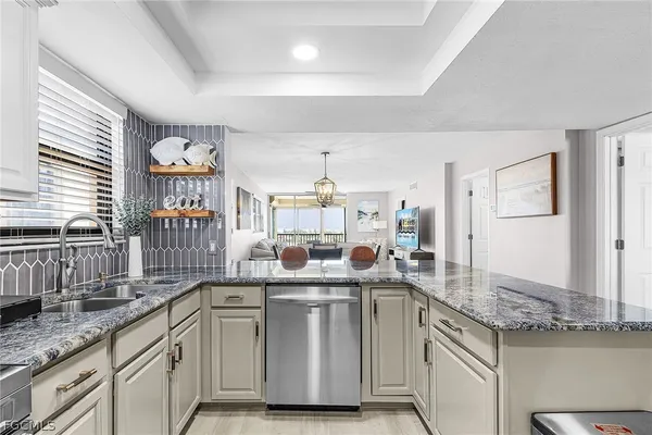 a kitchen with stainless steel appliances granite countertop a sink and a dishwasher