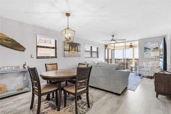 a dining room with furniture a chandelier and wooden floor