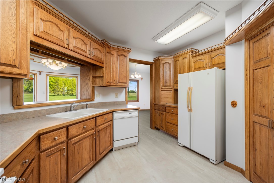 51488 Peck Wadsworth Road Wellington, OH 44090 - Photo 29 of 50 Kitchen featuring wood cabinetry, laminate countertops, a double-basin sink, and light-toned flooring