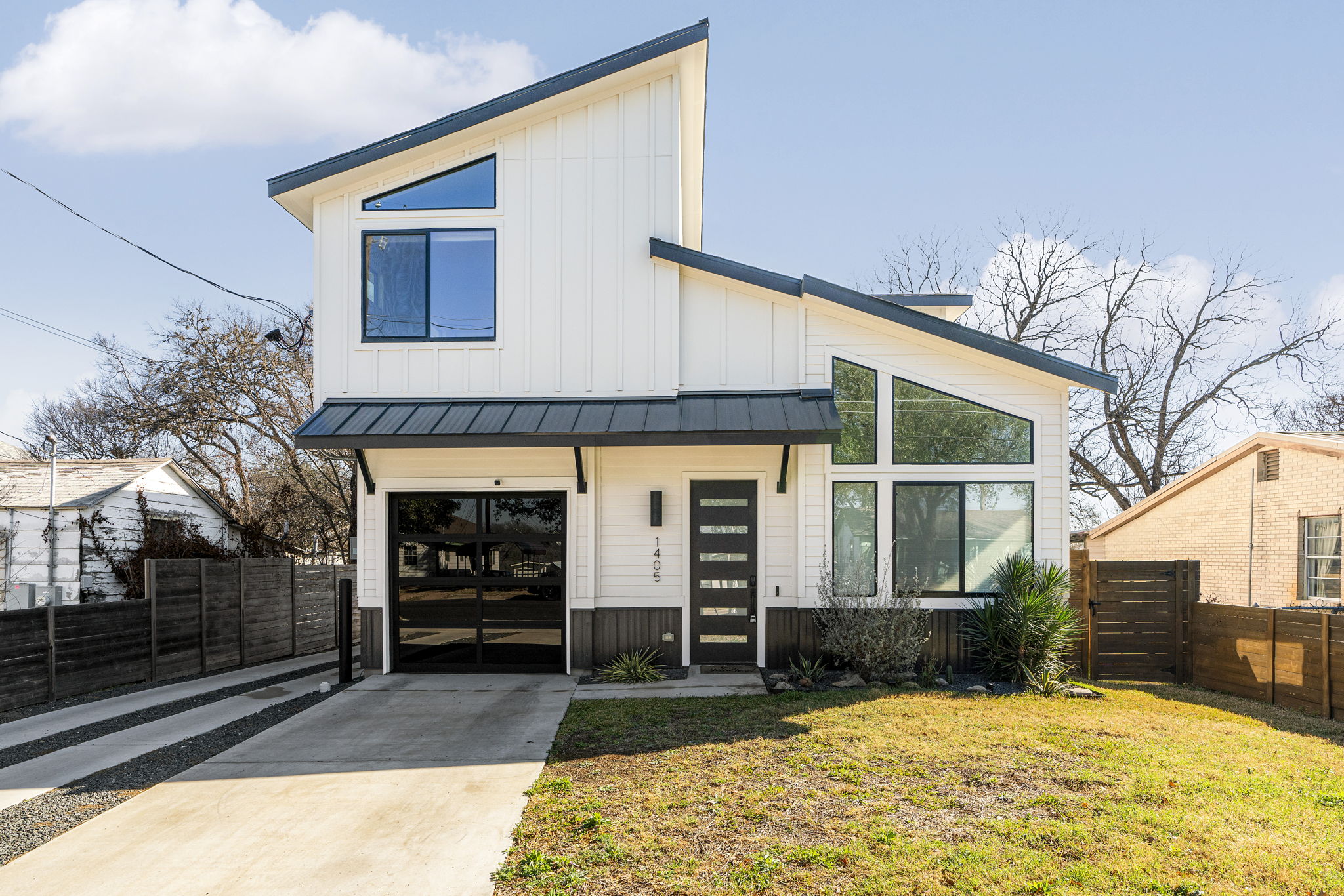 Modern front elevation with striking asymmetrical rooflines and expansive picture windows that bring natural light indoors.