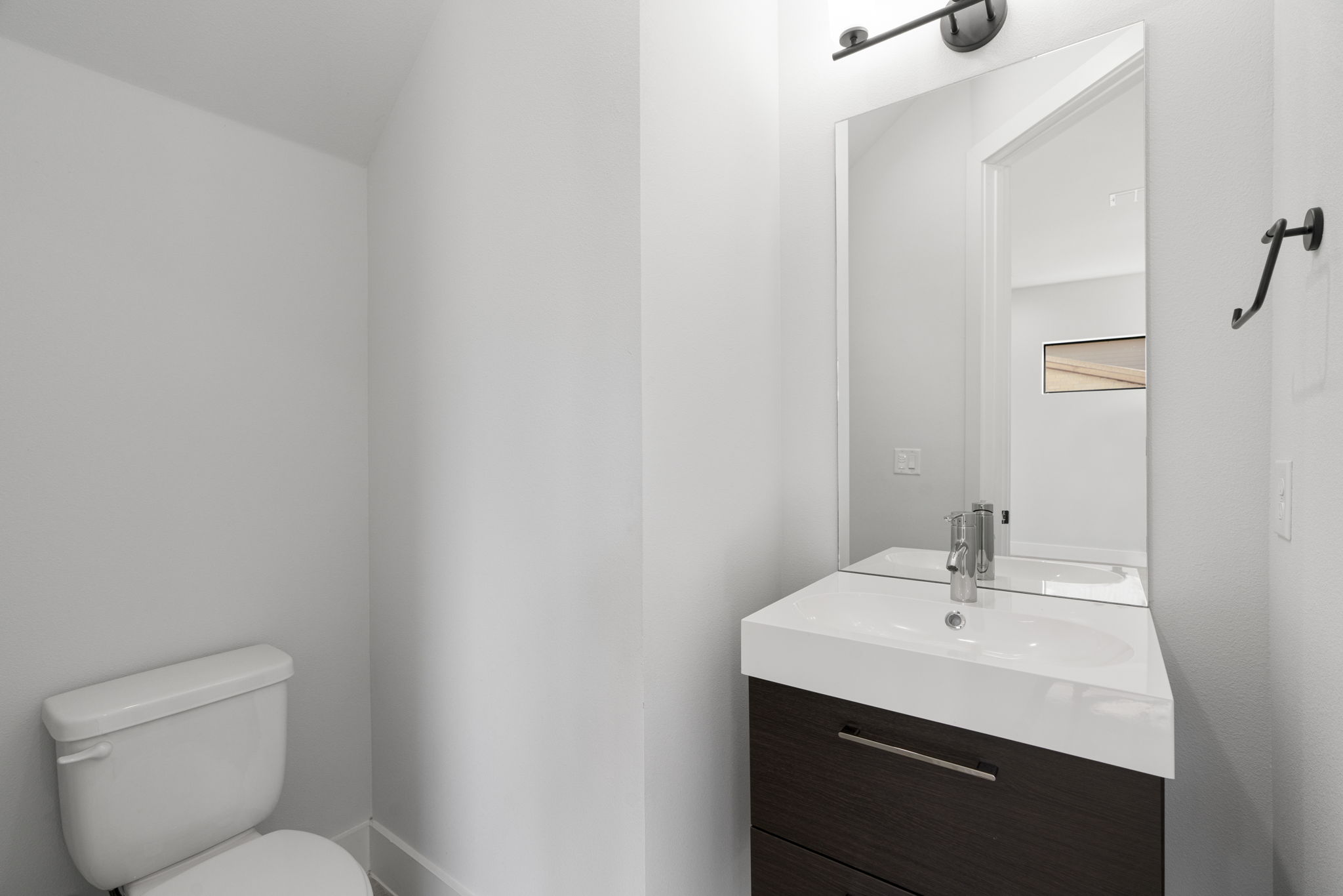 1405 Perez Street, Unit 1 Austin, TX 78721 - Photo 17 of 31 Main-level powder bath features a sleek floating-style vanity, modern fixtures, and streamlined design for guests.