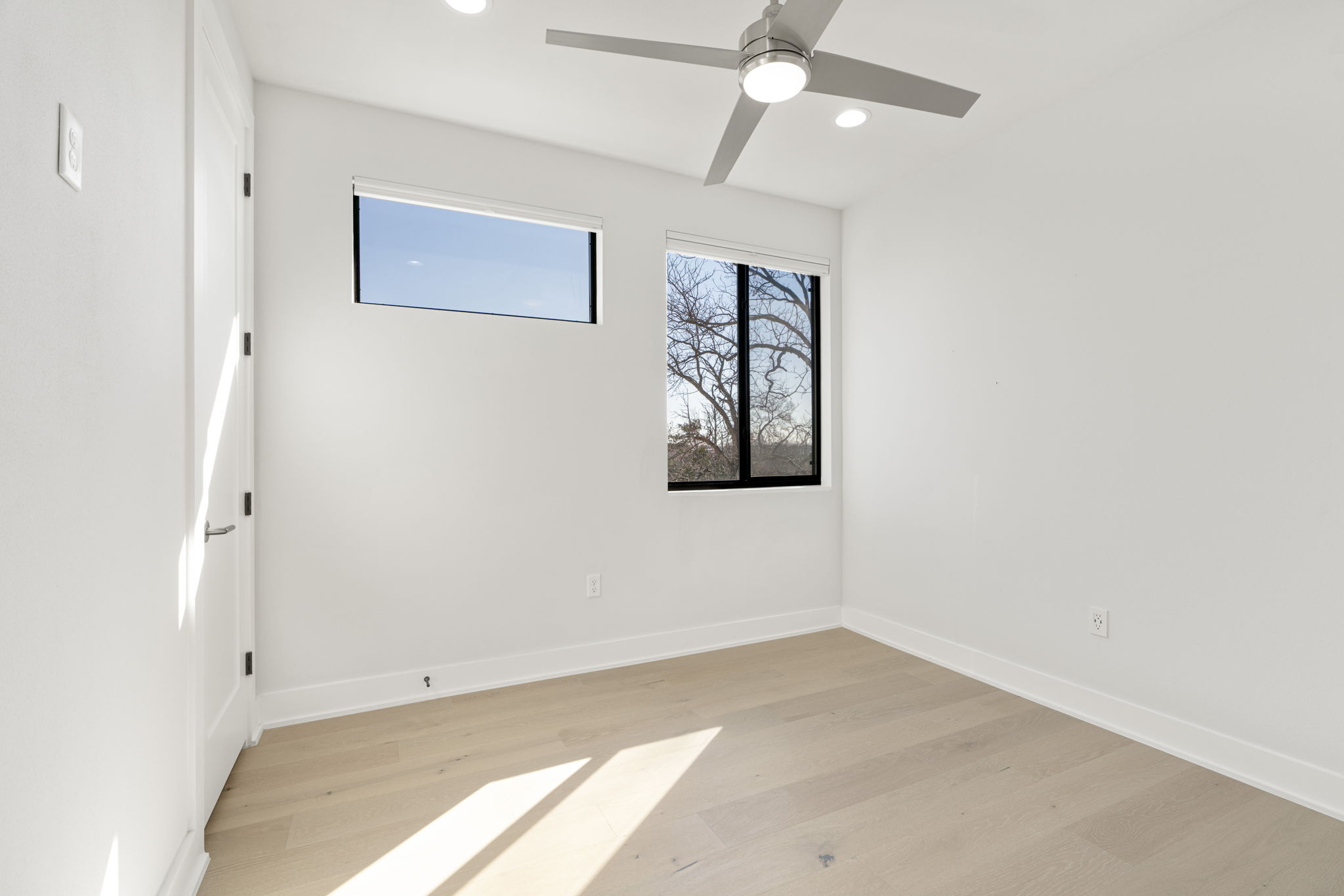 1405 Perez Street, Unit 1 Austin, TX 78721 - Photo 24 of 31 Bright secondary bedroom featuring wood floors, ceiling fan, and etreetop views.