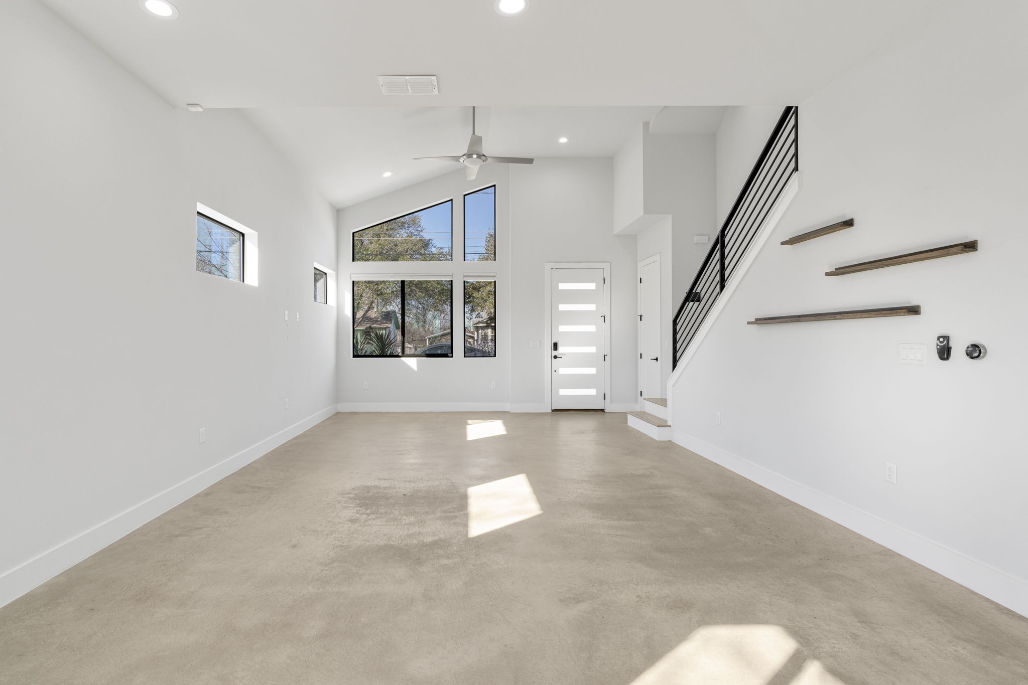1405 Perez Street, Unit 1 Austin, TX 78721 - Photo 4 of 31 Vaulted ceiling with modern ceiling fan and expansive front-facing windows creates a bright and inviting gathering space