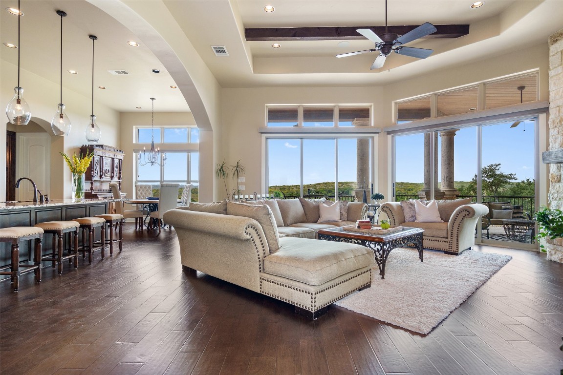 a living room with furniture kitchen view and a large window