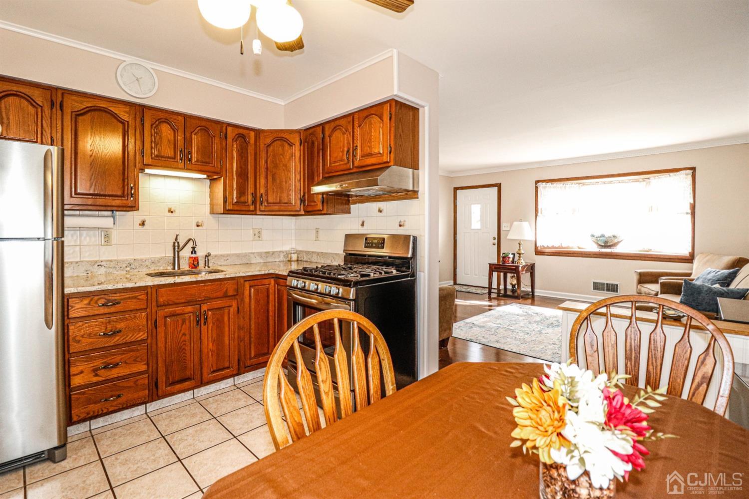 3 Avon Road Edison, NJ 08817 - Photo 12 of 39 a kitchen with stainless steel appliances granite countertop a refrigerator a sink dishwasher a dining table and chairs with wooden floor