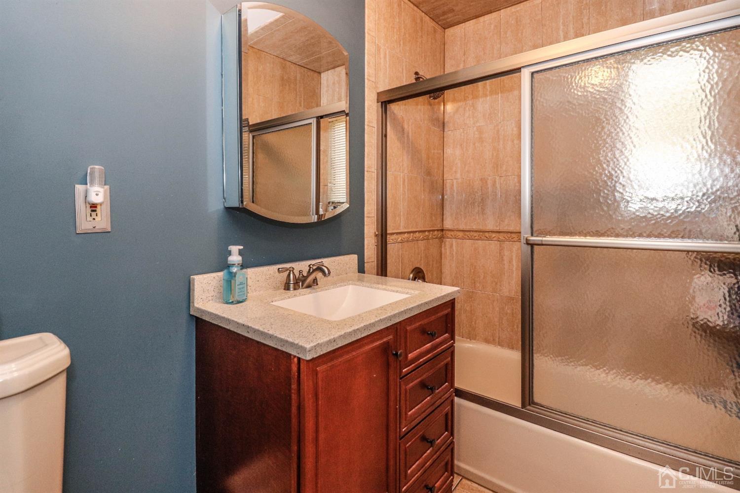 3 Avon Road Edison, NJ 08817 - Photo 29 of 39 a bathroom with a sink and mirror with window