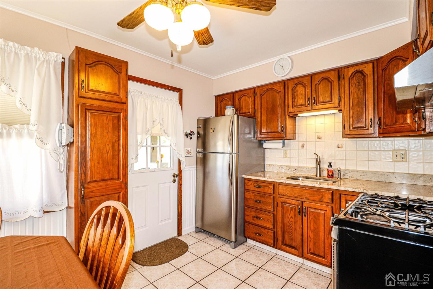 3 Avon Road Edison, NJ 08817 - Photo 9 of 39 a kitchen with stainless steel appliances granite countertop a refrigerator a sink dishwasher a stove and a dining table with wooden floor