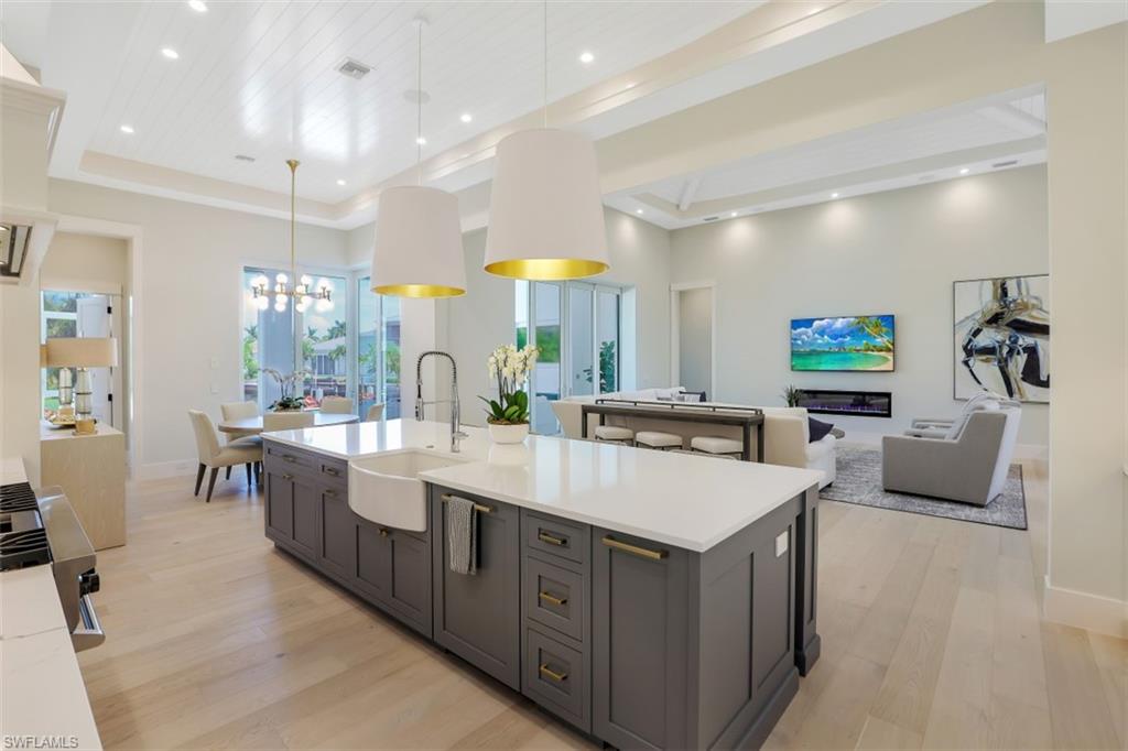 2130 Tarpon Road Naples, FL 34102 - Photo 18 of 35 a large kitchen with kitchen island a sink a counter top space and living room view