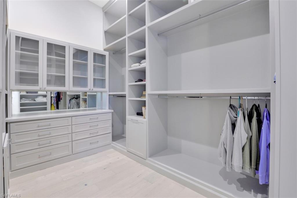 2130 Tarpon Road Naples, FL 34102 - Photo 23 of 35 a view of walk in closet with clothes and shoes
