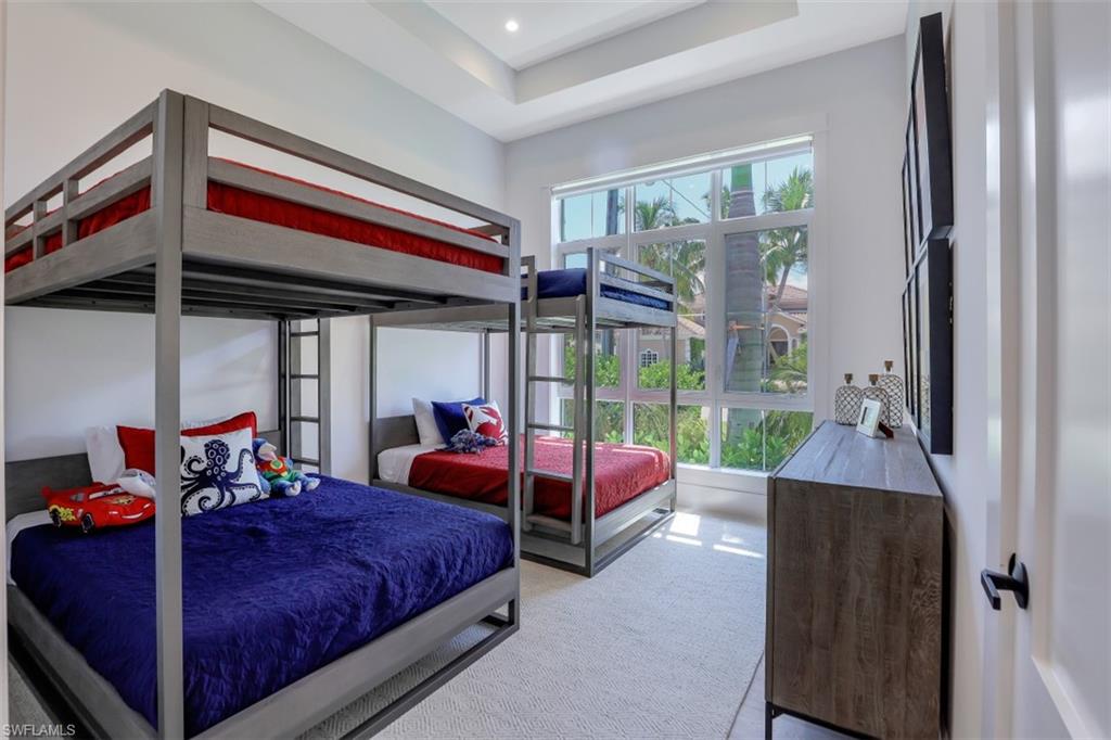 2130 Tarpon Road Naples, FL 34102 - Photo 26 of 35 a bedroom with a bed and large windows