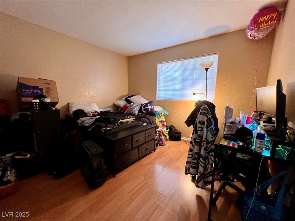 4730 East Craig Road, Unit 2071 Las Vegas, NV 89115 - Photo 14 of 23 Bedroom featuring a textured wall and light wood-style flooring