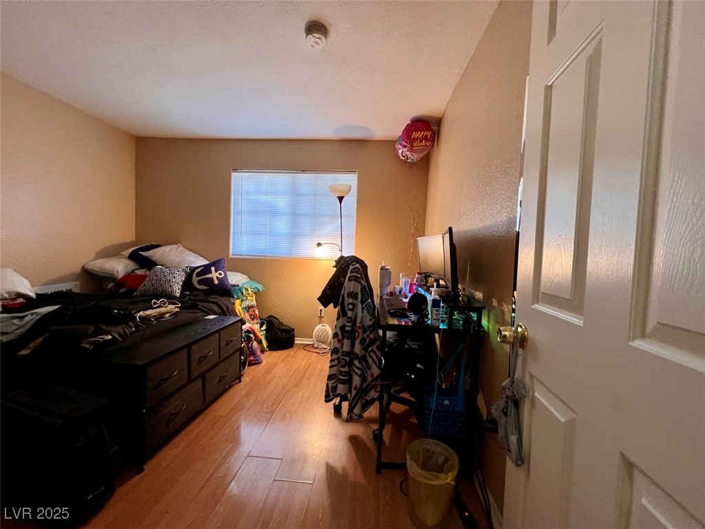 4730 East Craig Road, Unit 2071 Las Vegas, NV 89115 - Photo 15 of 23 Bedroom with a textured wall and light wood-style flooring