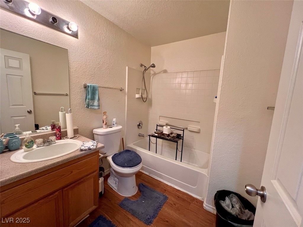 4730 East Craig Road, Unit 2071 Las Vegas, NV 89115 - Photo 16 of 23 Full bathroom with a textured wall, vanity, dark wood-style flooring, bathing tub / shower combination, and a textured ceiling