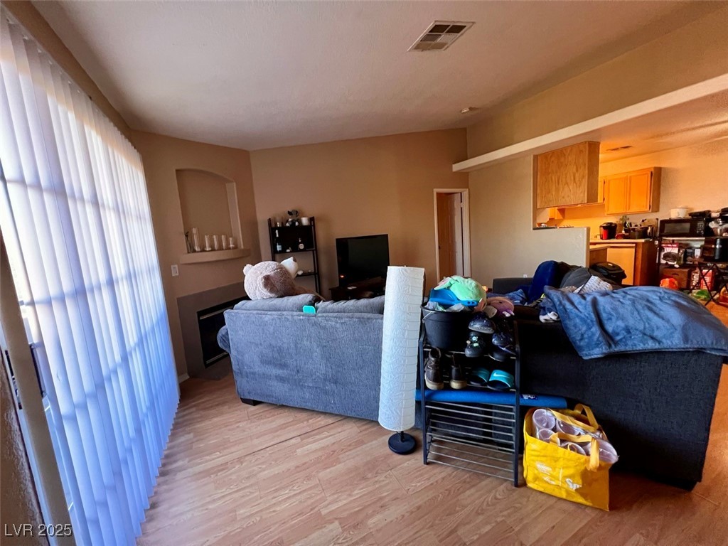 4730 East Craig Road, Unit 2071 Las Vegas, NV 89115 - Photo 4 of 23 Living area with light wood-style floors and a fireplace
