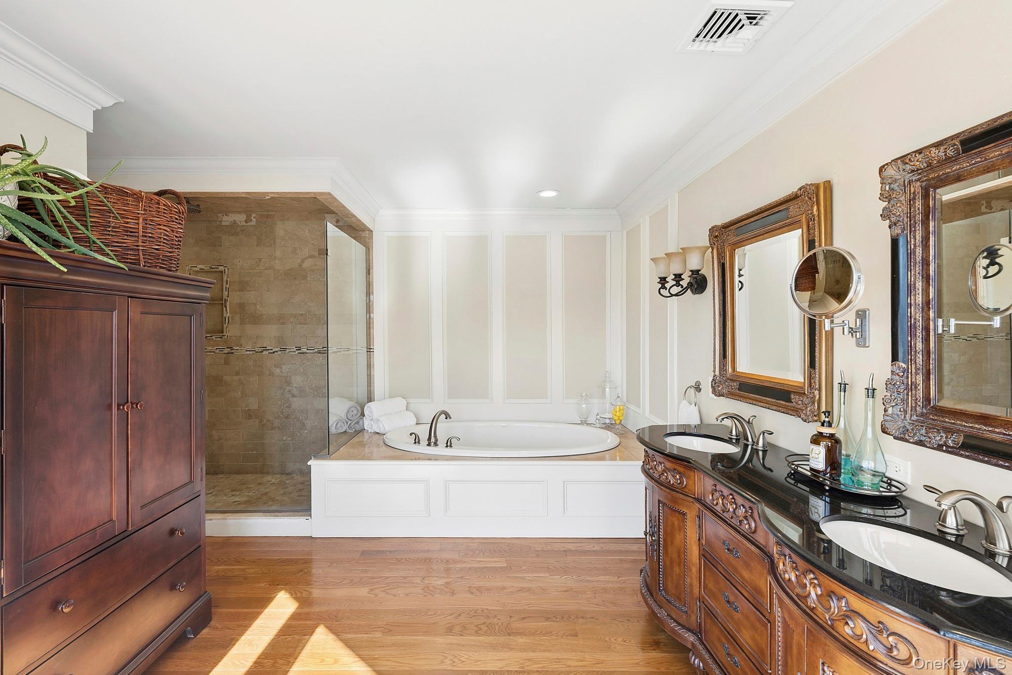 5 Woodcock Lane Remsenburg, NY 11960 - Photo 17 of 23 a bathroom with a double vanity sink a mirror and a bathtub
