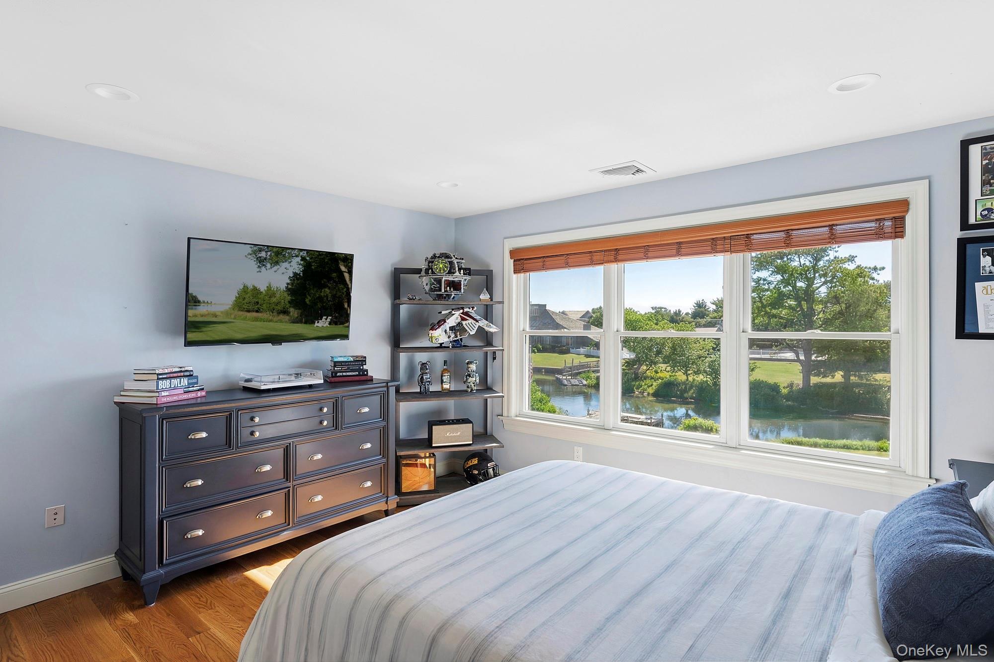 5 Woodcock Lane Remsenburg, NY 11960 - Photo 18 of 23 a bedroom with a bed and a flat screen tv