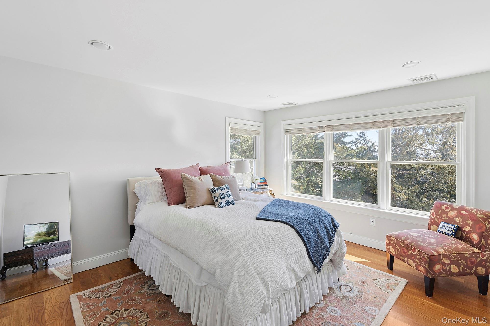 5 Woodcock Lane Remsenburg, NY 11960 - Photo 19 of 23 a bedroom with a bed and a large window