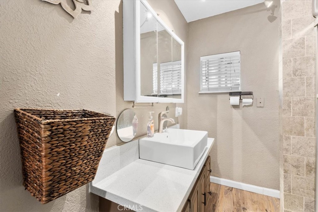 3974 5th Street Riverside, CA 92501 - Photo 23 of 45 a bathroom with a granite countertop sink a vanity and a shower