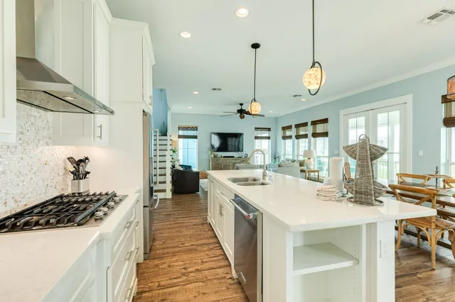 a large kitchen with stainless steel appliances a large center island attached withe living room