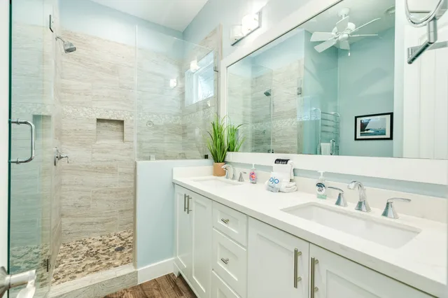 a bathroom with a double vanity sink mirror and shower