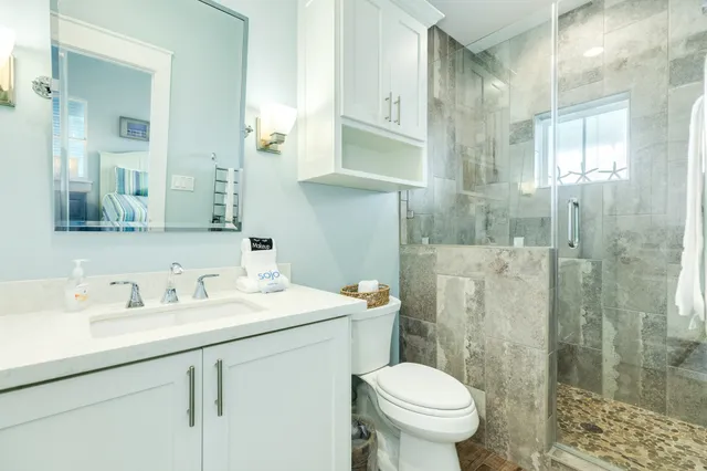 a bathroom with a sink toilet vanity and shower