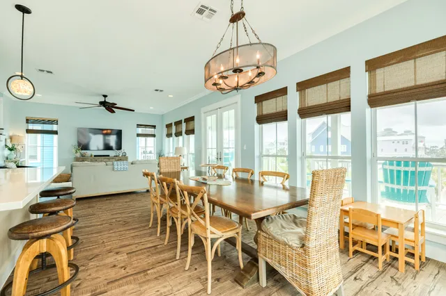 a view of a dining room with furniture large windows and wooden floor