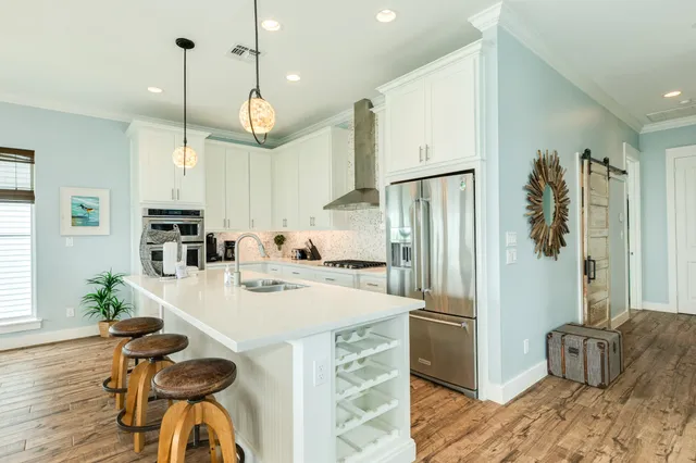 a kitchen with a refrigerator a sink and chairs