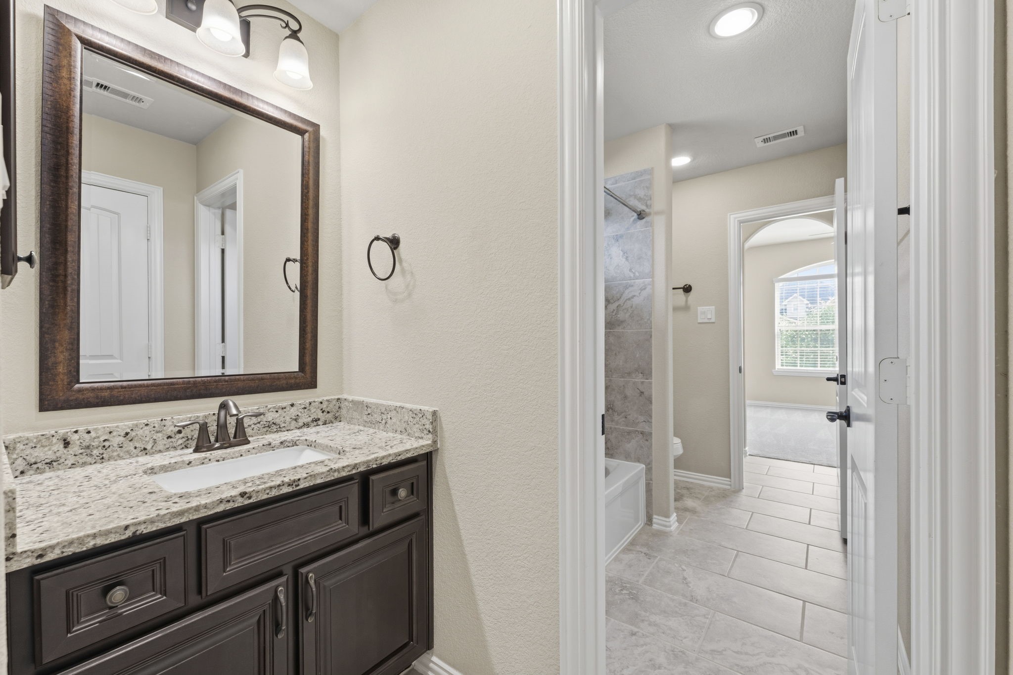 25210 Gaddis Oaks Drive Spring, TX 77389 - Photo 31 of 50 a bathroom with a granite countertop sink mirror and a shower