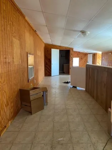 a view of an empty room with wooden floor and furniture