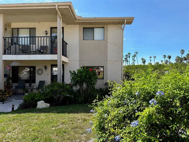 a view of a house with potted plants and a fountain