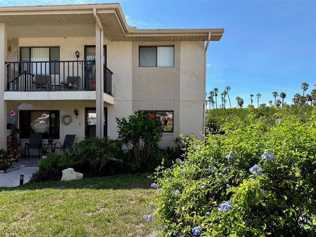 a view of a house with potted plants and a fountain
