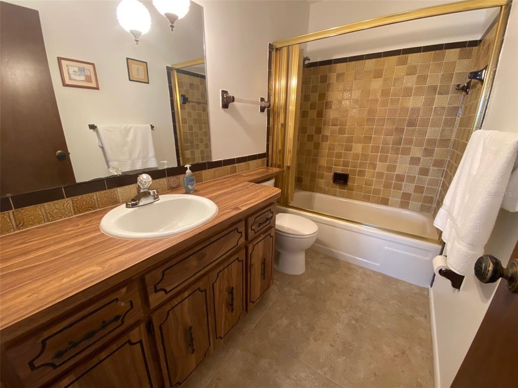 9940 Eagles Point Circle, Unit 4 Port Richey, FL 34668 - Photo 21 of 53 a bathroom with a sink a toilet a mirror and shower