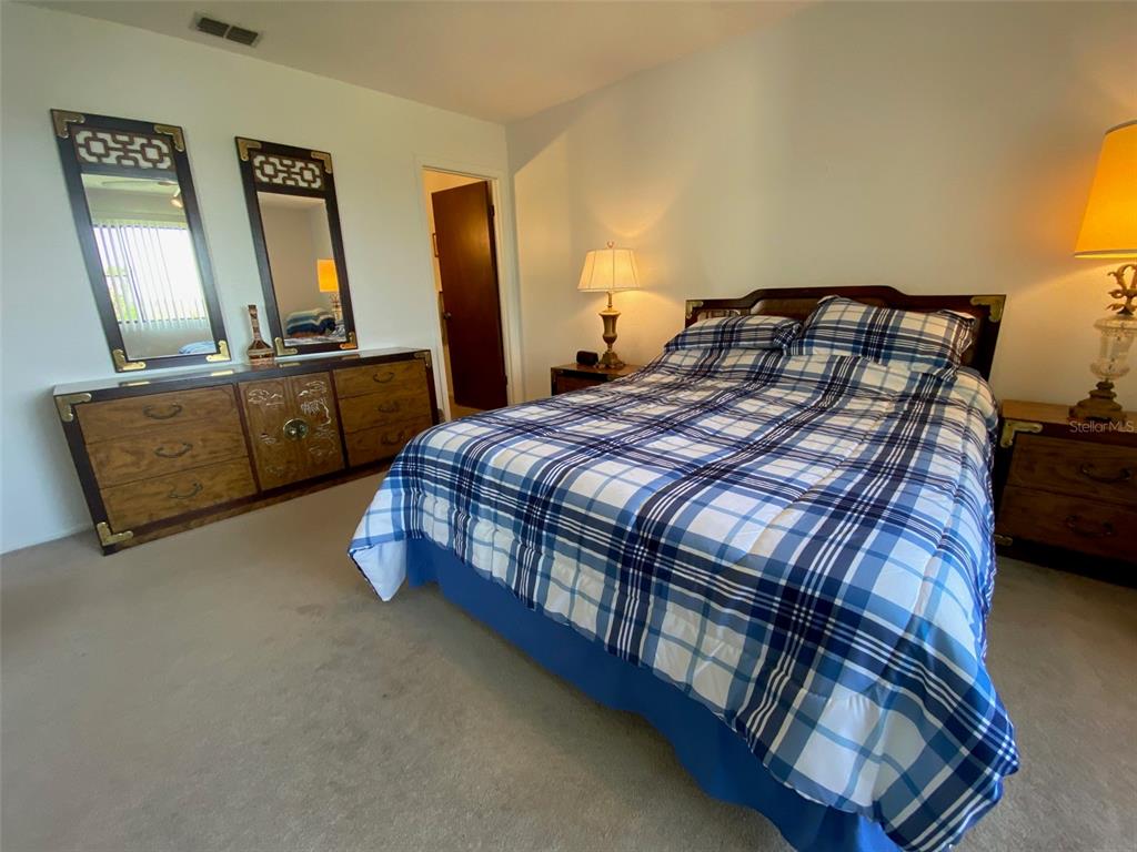 9940 Eagles Point Circle, Unit 4 Port Richey, FL 34668 - Photo 25 of 53 a bedroom with a bed and wooden floor