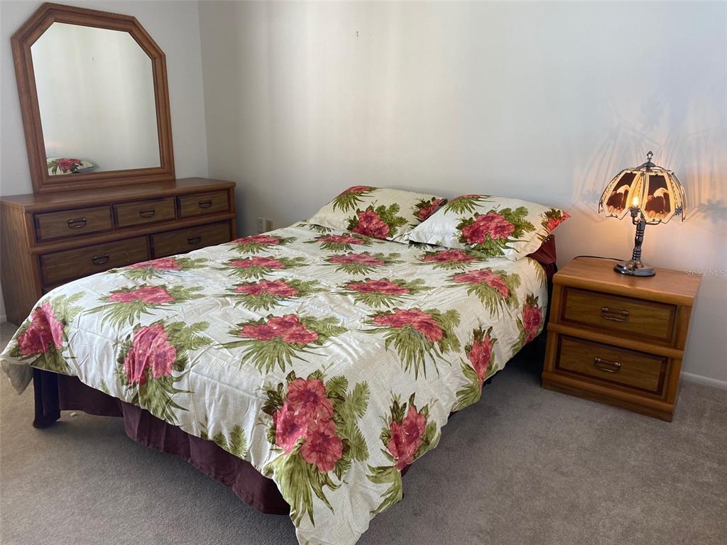 9940 Eagles Point Circle, Unit 4 Port Richey, FL 34668 - Photo 27 of 53 a bedroom with a bed and a dresser