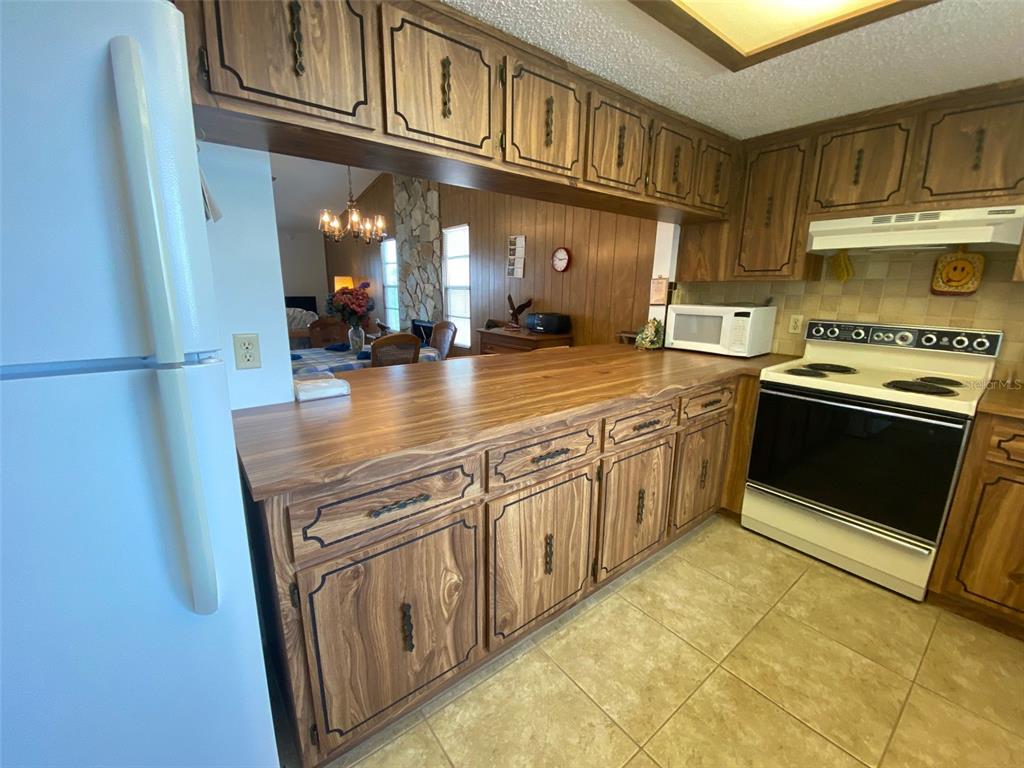 9940 Eagles Point Circle, Unit 4 Port Richey, FL 34668 - Photo 4 of 53 a kitchen with stainless steel appliances granite countertop a stove a sink and a refrigerator