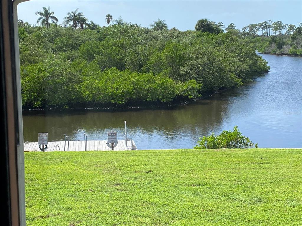 9940 Eagles Point Circle, Unit 4 Port Richey, FL 34668 - Photo 41 of 53 a view of a lake with a garden and trees