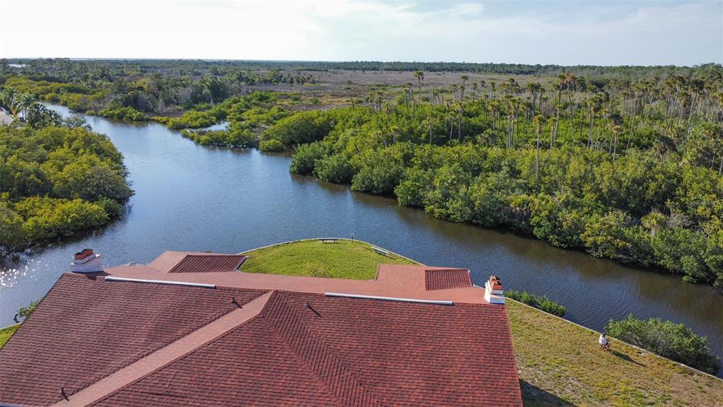9940 Eagles Point Circle, Unit 4 Port Richey, FL 34668 - Photo 49 of 53 an aerial view of a house with a yard and lake view