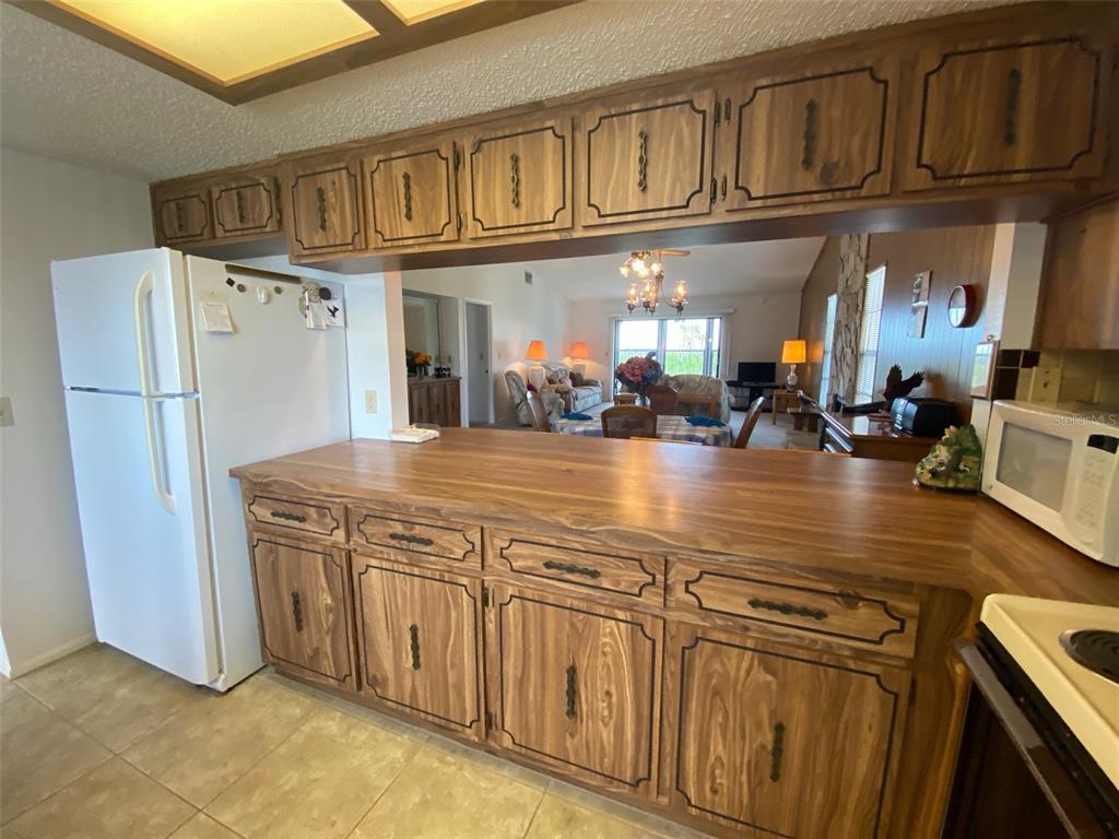 9940 Eagles Point Circle, Unit 4 Port Richey, FL 34668 - Photo 6 of 53 a kitchen with stainless steel appliances granite countertop a refrigerator a stove and a sink with dishwasher