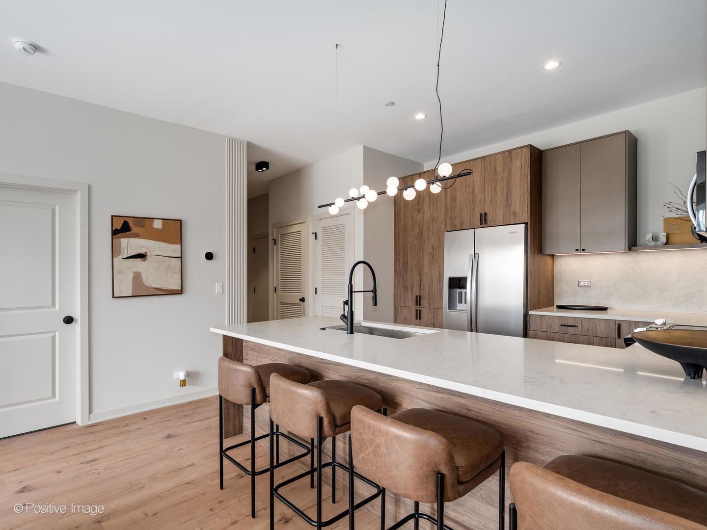 1235 North Ashland Avenue, Unit 301 Chicago, IL 60622 - Photo 14 of 25 a kitchen with stainless steel appliances a dining table chairs and a refrigerator