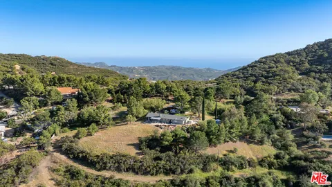 an aerial view of a house with a yard and garden