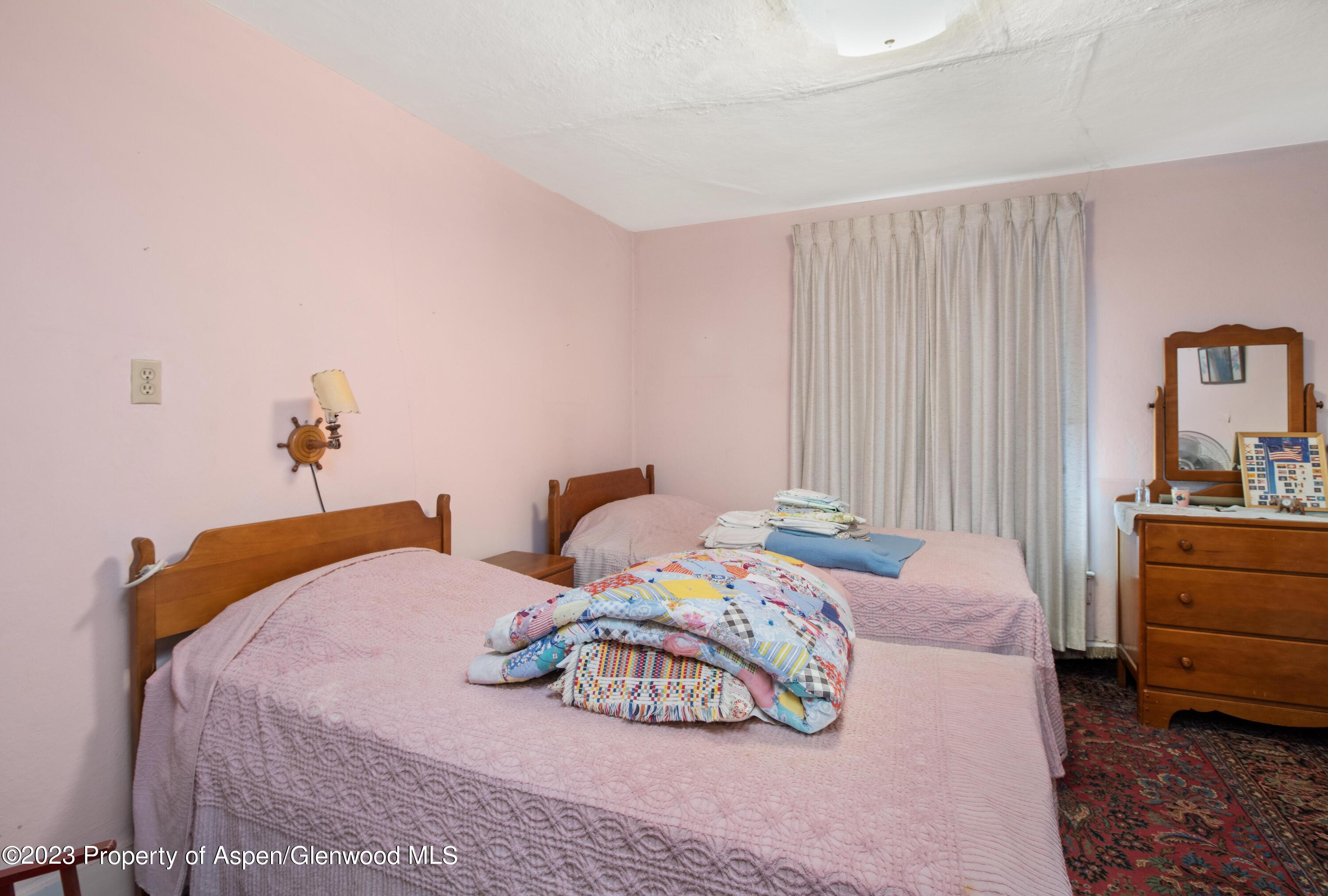 302 East 6th Street Rifle, CO 81650 - Photo 12 of 14 a bedroom with two bed and a dresser