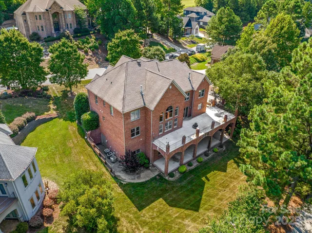 an aerial view of a house with a big yard and large trees